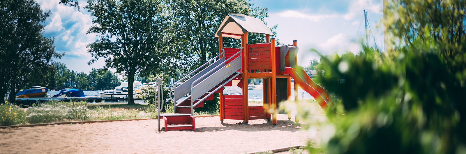 Ein Spielplatz mit einem Spielhaus und einer Rutsche.